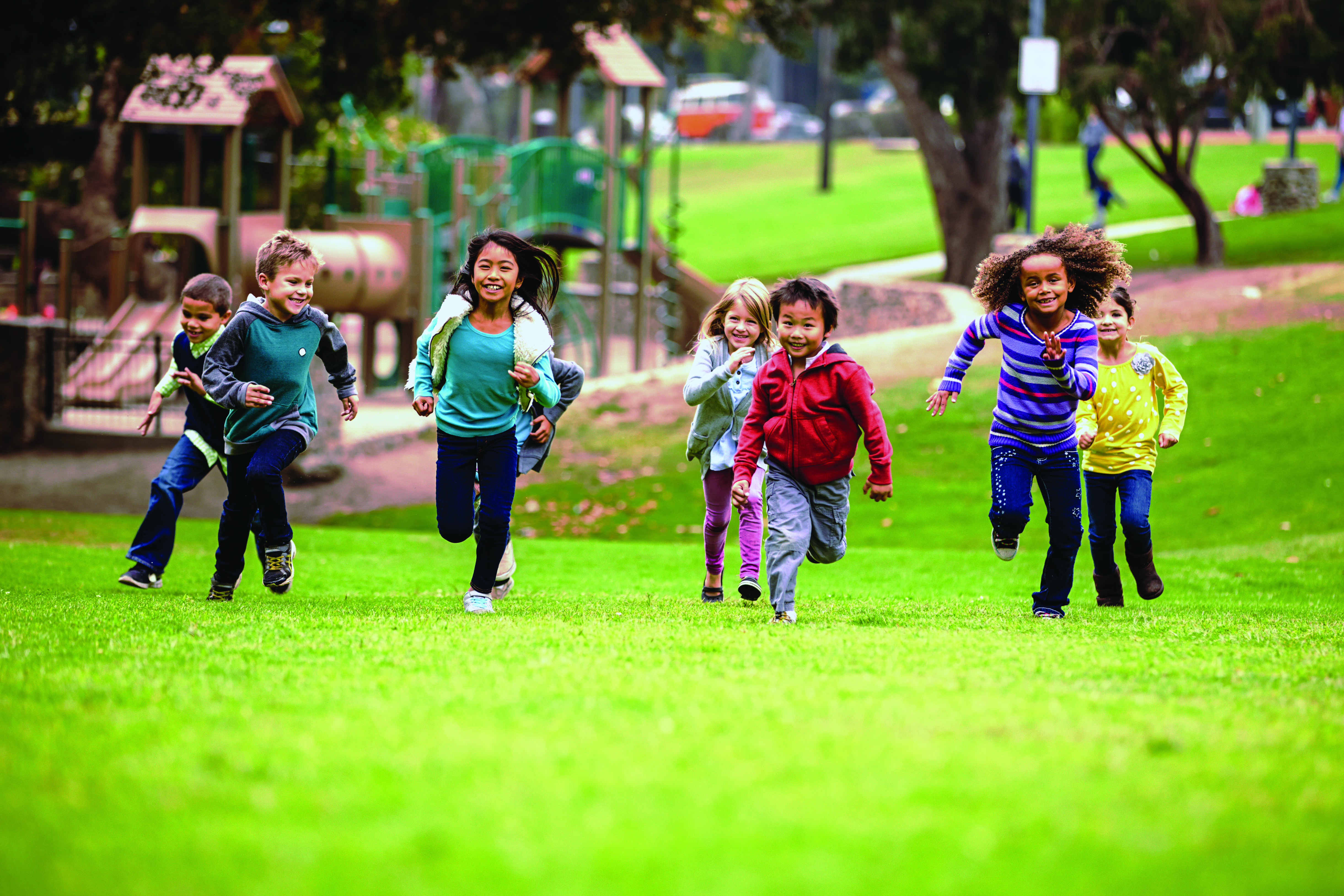 Group Of Young Children Running Towards Camera In Park - LPHI
